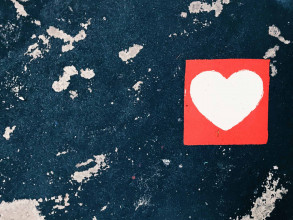 a red and white heart painted on a black wall